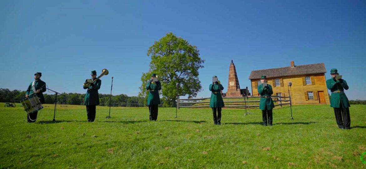 Six college-age men in bright green uniforms of antebellum American style are playing